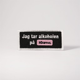 Svart tygmärke med texten 
