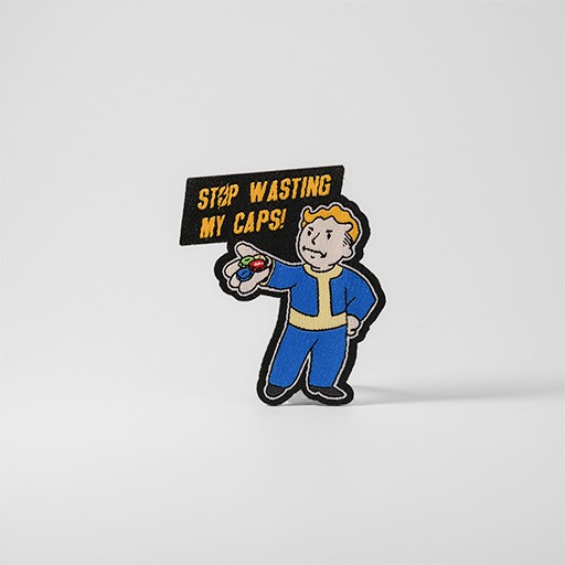 Gult och blått Fallout-tygmärke med texten "Stop Wasting My Caps!"