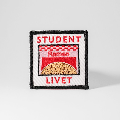 Vitt tygmärke med texten "Studentlivet" och ett paket ramen-nudlar